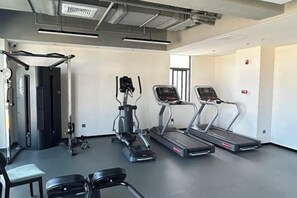 A modern gym with treadmills, elliptical machines, and weight benches. - Xiamen Jingbang Hotel (Xiamen)