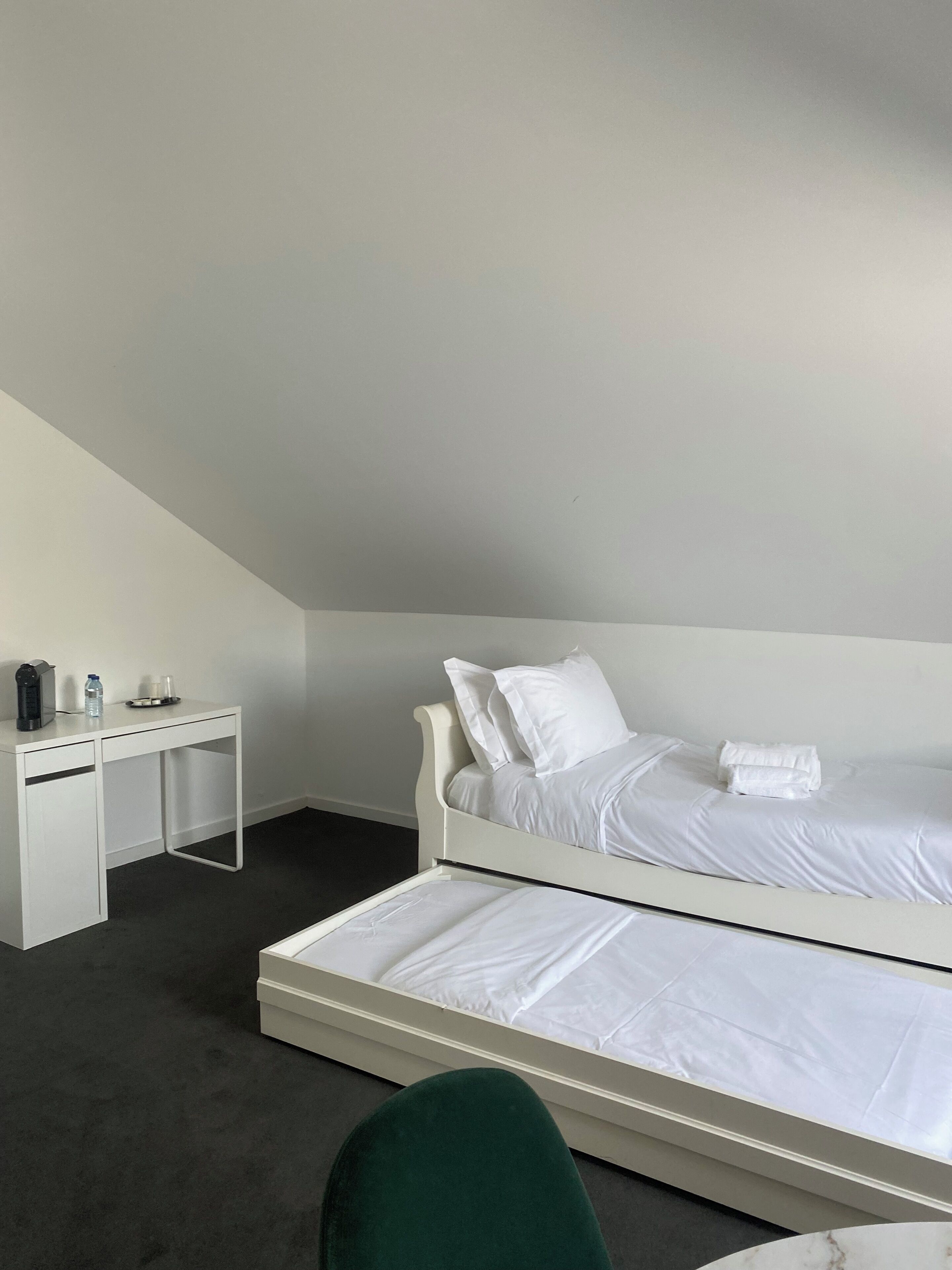 A hotel room with a single bed, a desk, and a chair.