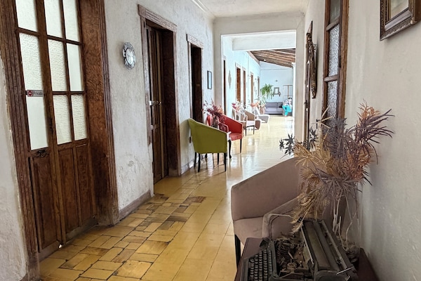 Quarto casal conforto, vista para o pátio | Área de estar