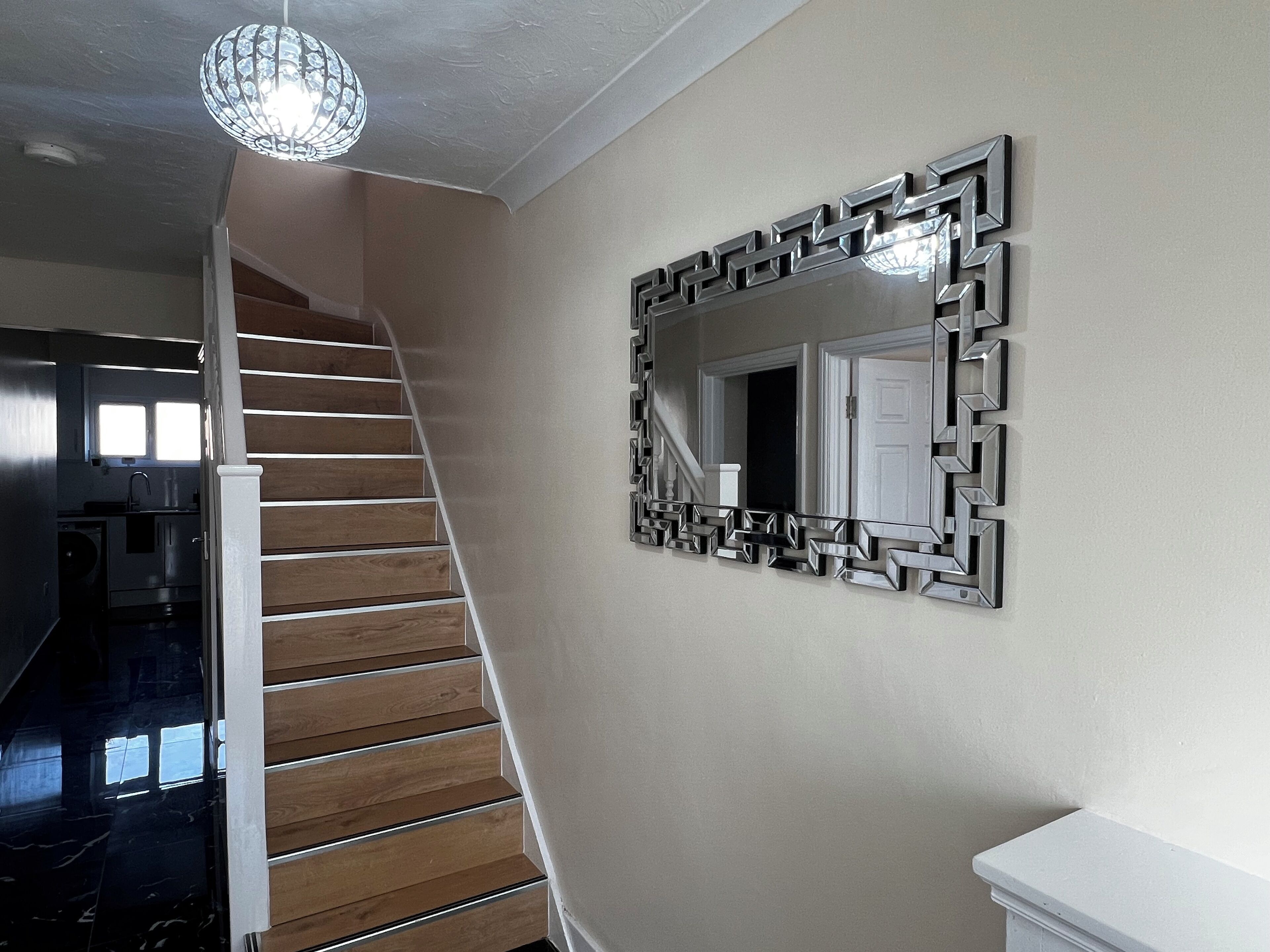 A staircase with wooden steps and a modern light fixture above it.