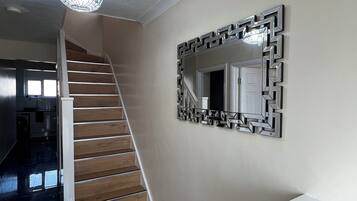 A staircase with wooden steps and a modern light fixture above it.