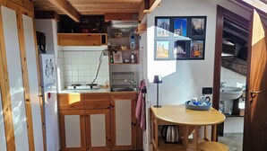 Une cuisine compacte avec des meubles en bois, un évier et un coin repas équipé de tabourets.