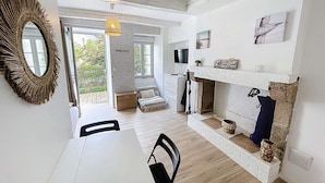 A modern interior with a dining area, a fireplace, and a view of the outdoors. - Charming newly renovated studio with terrace - pets allowed, free Wi-Fi (Granville)