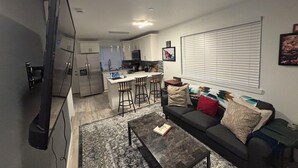 Un appartement moderne comprenant une cuisine, un coin repas et un salon.
