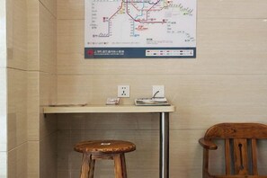 A reception area with a map, a desk, a chair, and a stool. - Homeinn Pebble (Shanghai Qian Tan Shangnan Road Subway Station) (Shanghai)