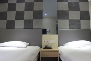 A hotel room with two beds, a small bedside table with a phone, and a mirror. - Homeinn Pebble (Shanghai Qian Tan Shangnan Road Subway Station) (Shanghai)