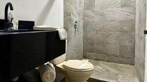 A bathroom with a black sink, a toilet, and a shower area with stone tiles. - Playa Mantas studio, AC, Parking (Quebrada Ganado)