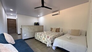 A hotel room with a bed, a sofa, a wardrobe, and a ceiling fan. - Playa Mantas studio, AC, Parking (Quebrada Ganado)