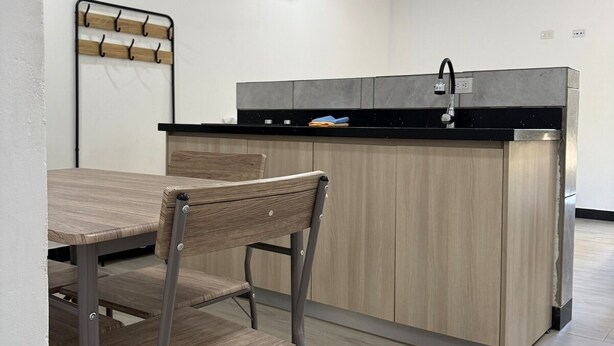 A modern kitchen with a central island, a dining table with chairs, and a ceiling fan. - Playa Mantas studio, AC, Parking (Quebrada Ganado)