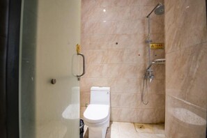 A small bathroom with a toilet, a shower, and a marble wall. - Mingjun Fashion Hotel (Shangqiu)