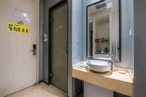 A modern bathroom with a large sink, a mirror, and a door with a WiFi sign. - Mingjun Fashion Hotel (Shangqiu)