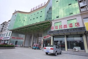 Un hotel con una facciata moderna, un ingresso coperto e una targa ben visibile.