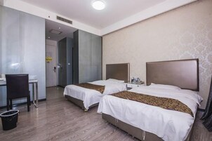 Una habitación de hotel con dos camas, un escritorio y una silla.