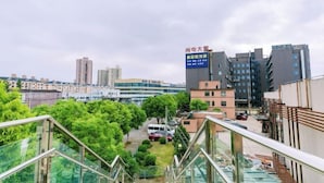 A view from a high-rise building overlooking a cityscape with modern buildings, a parking area, and greenery. - Jitai Boutique Hotel (Shanghai Expo Park Gaoke West Road Subway Station) (Shanghai)