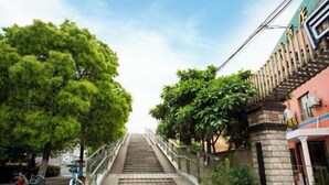 A staircase leading up to a building with a stone facade and a sign that reads "Hotel". - Jitai Boutique Hotel (Shanghai Expo Park Gaoke West Road Subway Station) (Shanghai)