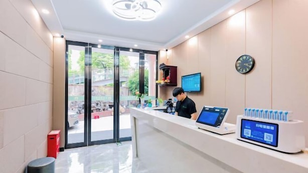 A modern reception area with a receptionist, a computer, and a digital kiosk. - Jitai Boutique Hotel (Shanghai Expo Park Gaoke West Road Subway Station) (Shanghai)