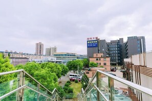 A cityscape with modern buildings, a clear sky, and a view of a residential area with greenery.