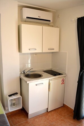 Efficient kitchenette with sink, refrigerator, and microwave.