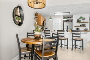 A modern kitchen with white cabinets, a central island, and pendant lighting.