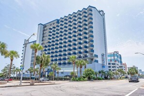 A high-rise hotel with a modern design, featuring a grid of balconies and a prominent blue and white color scheme.