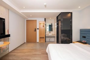 A modern hotel room with a bed, a TV, a bathroom, and a wardrobe. - Qicheng Hotel (Shenzhen Guanlan Dahe Road) (Shenzhen)