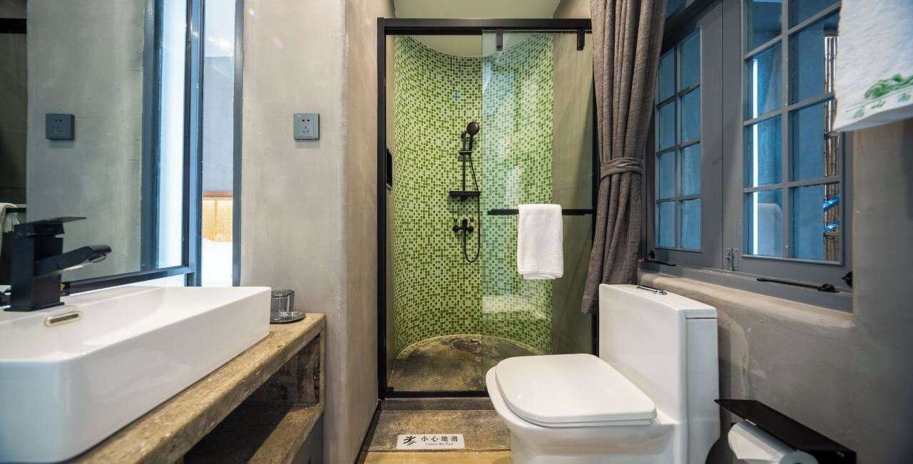 Ein Badezimmer mit Dusche, Toilette und Waschbecken.