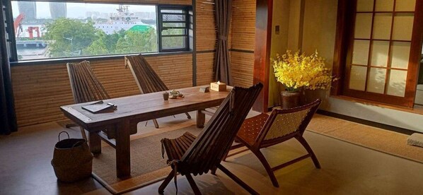 Una habitación tradicional japonesa con suelo de tatami, una mesa de madera baja y puertas correderas shoji.