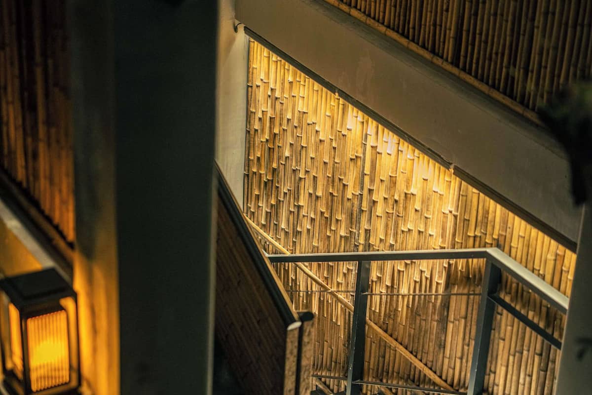 Eine Treppe mit Bambuswand und einer Laterne links.