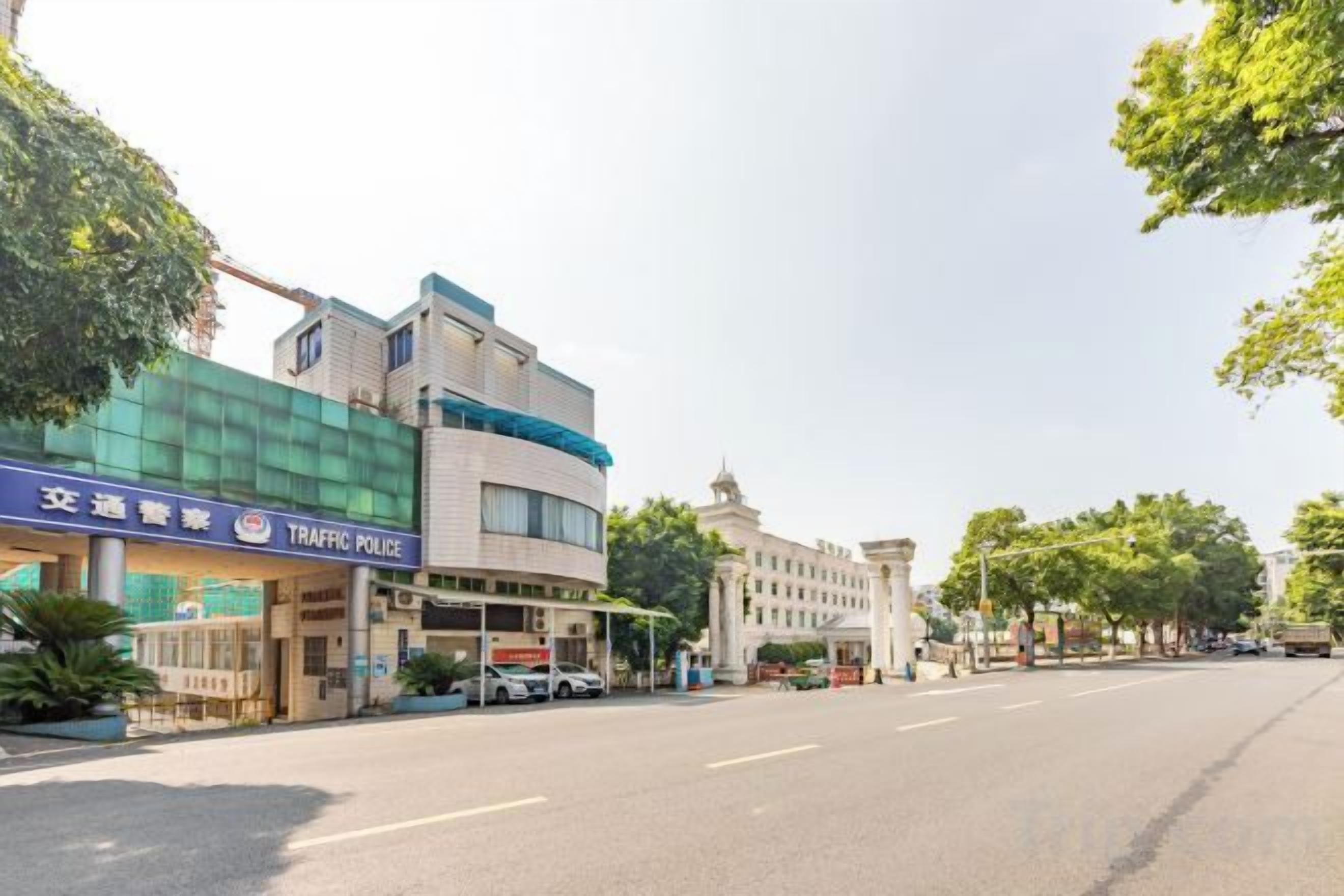 A building with a sign that reads 'TRAFFIC POLICE' and a clear road in front.