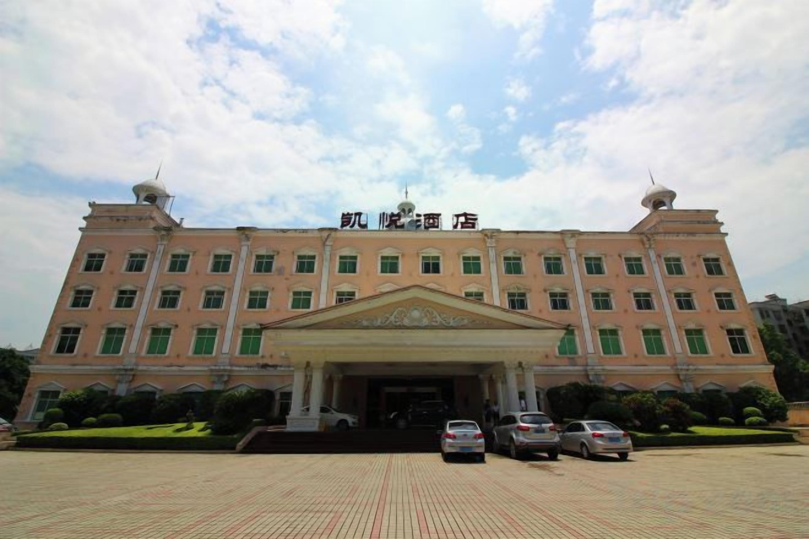 Un grand bâtiment doté d’une entrée centrale, de nombreuses fenêtres et d’un toit plat.