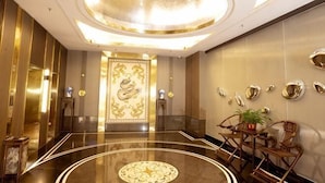 A spacious lobby with a central ornate door, a circular patterned floor, and a ceiling with a recessed light fixture. - Kaiyue Hotel (Shaoguan)