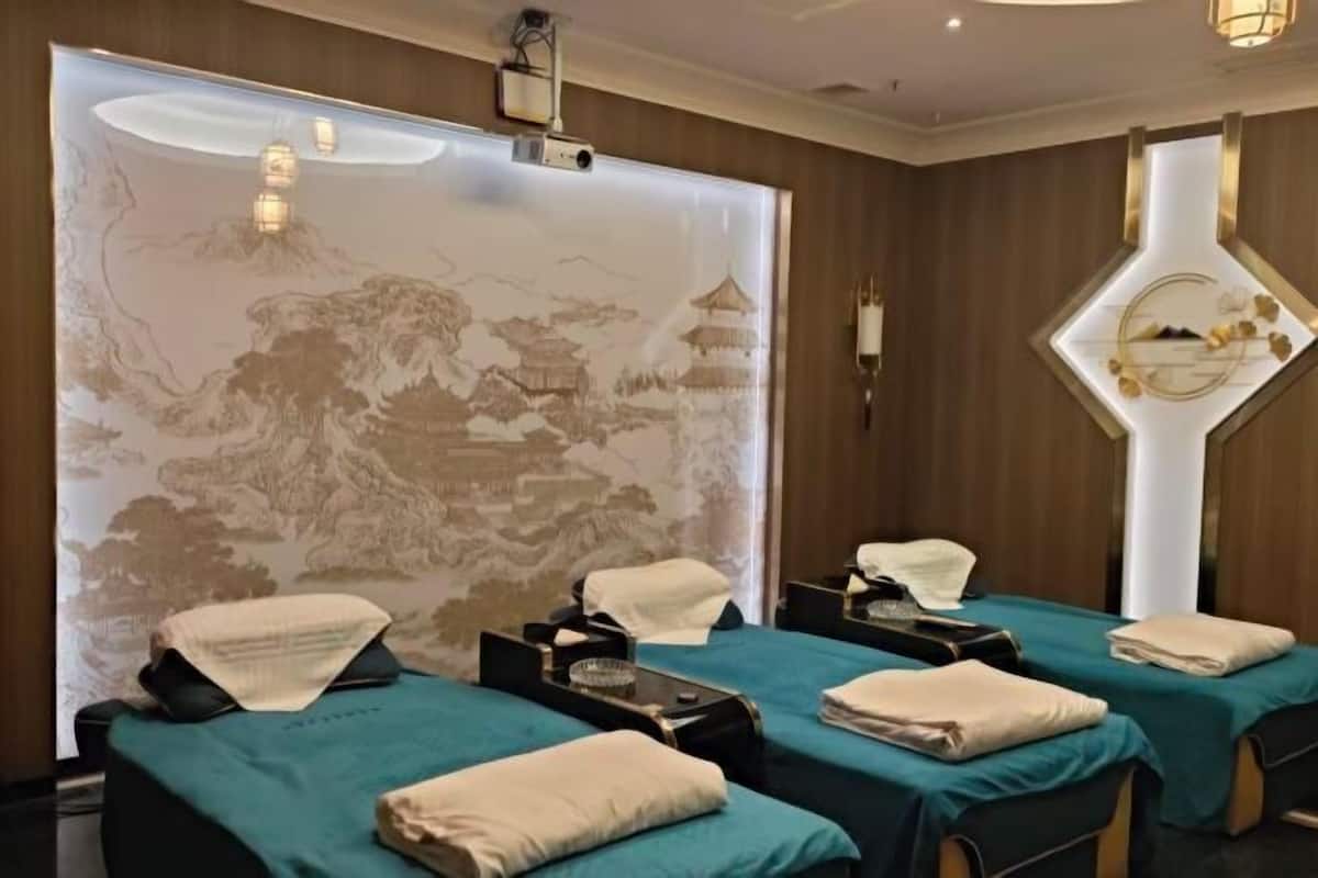 Una habitación con dos camas, un mural grande en la pared y un adorno decorativo.
