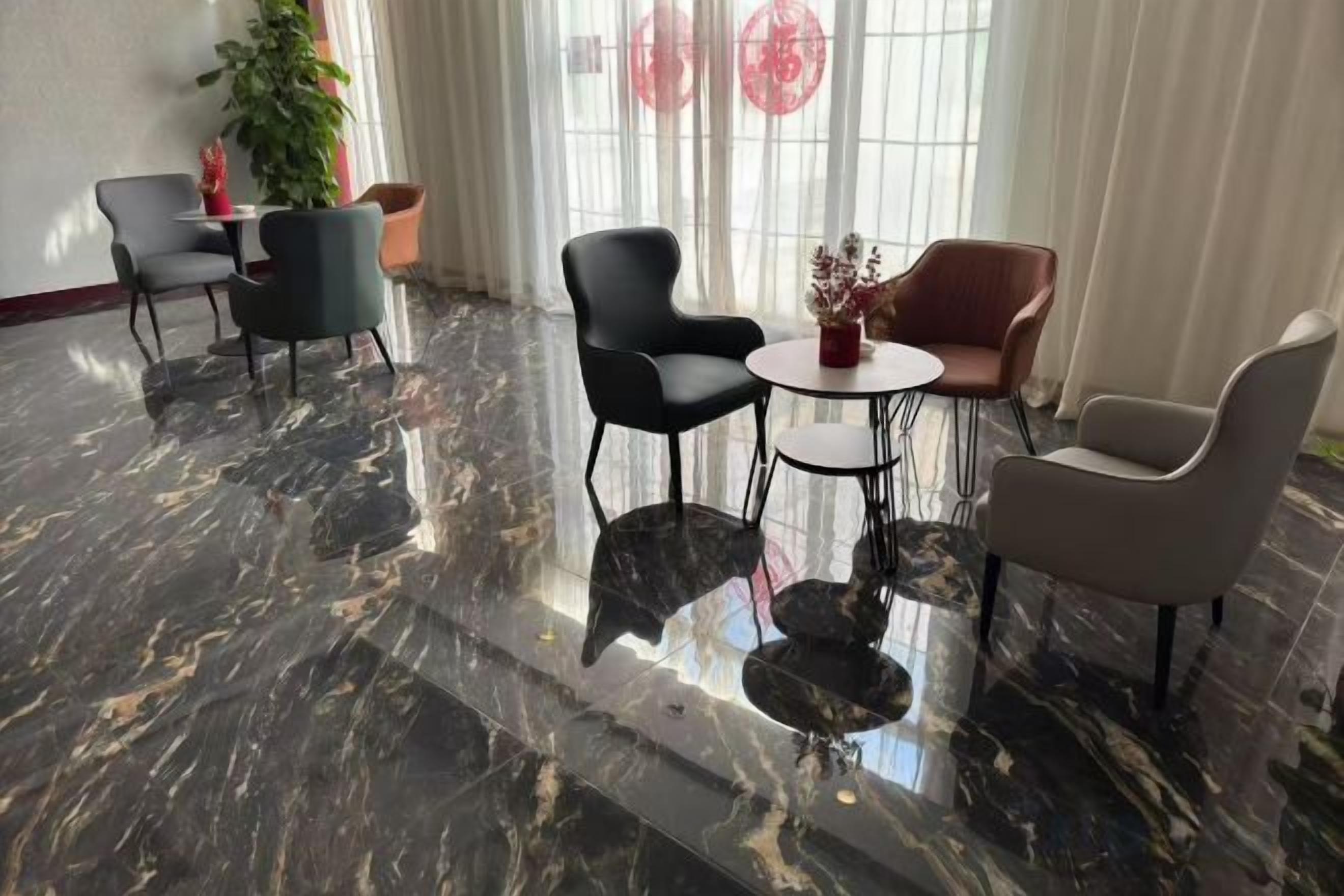 Un vestíbulo con piso de mármol, una mesa redonda y cuatro sillas.