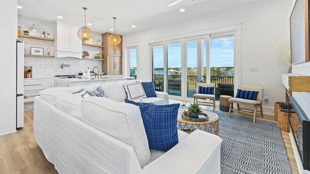A modern living space with a kitchen, dining area, and a balcony with a view. - Luxury 10 BR Beach House Amazing View Private Pool (Gulf Shores)