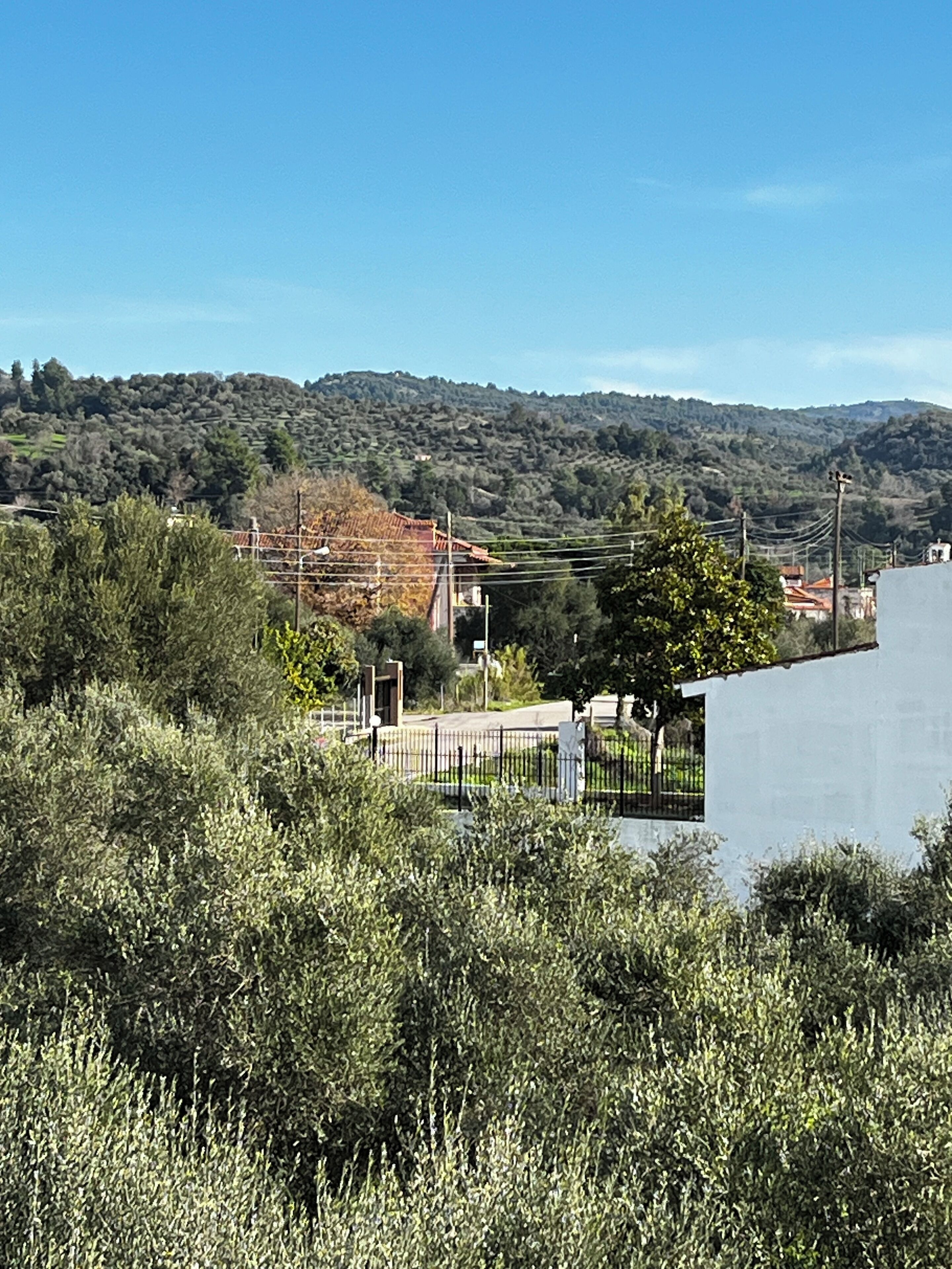 Un paisaje costero con una carretera, edificios y colinas al fondo.