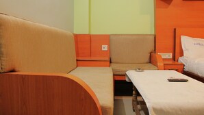 Une chambre d’hôtel avec un canapé, un fauteuil, un lit et une table de chevet.