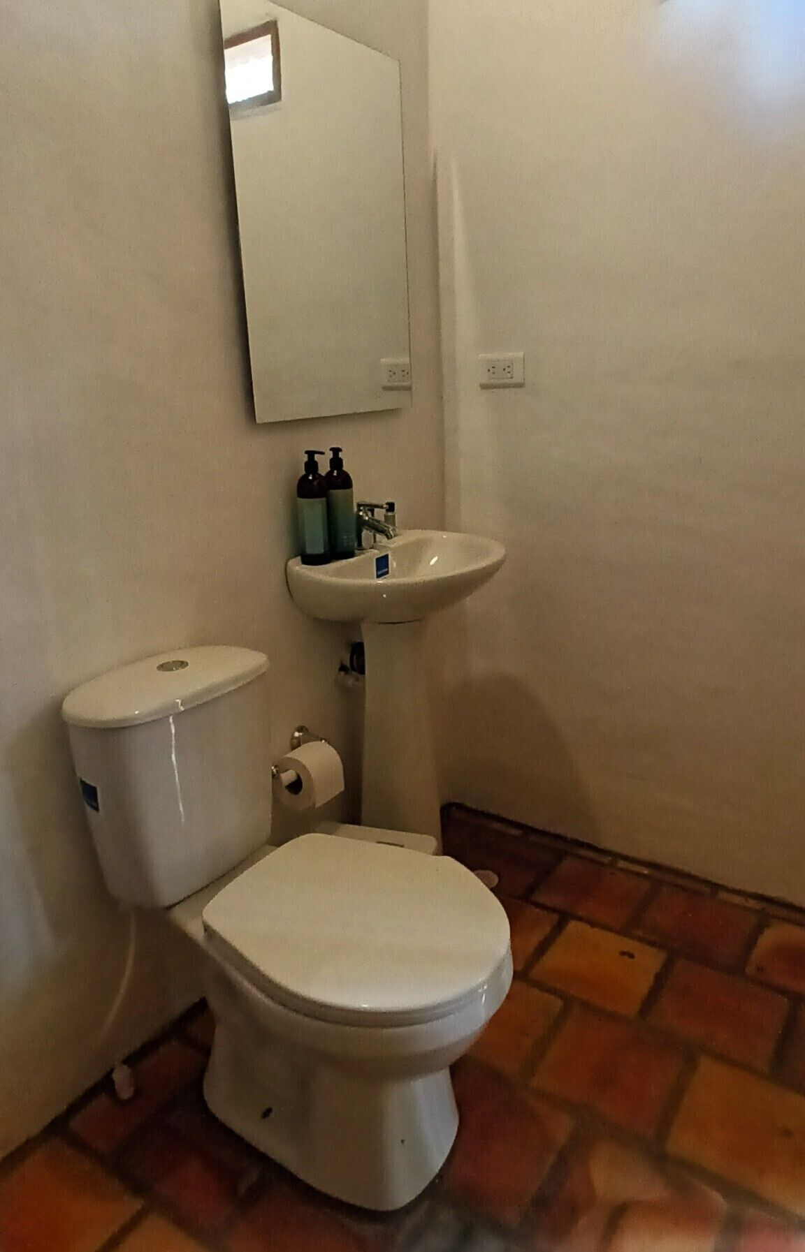 Ein Badezimmer mit Toilette, Waschbecken und Spiegel.