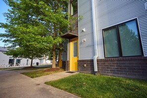 A building with a yellow door, large windows, and a tree in front. - Nashville`s Wildwest Getaway! (Nashville)