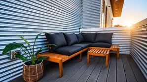Ein moderner Außenbereich mit einer Sitzecke, einem Couchtisch aus Holz und einem Blumentopf.