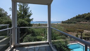 Een balkon met uitzicht op een zwembad en een strand.