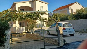 A residential building with a car parked in front. - Beachfront Apartment With Balcony and Sea View (Vrsi)