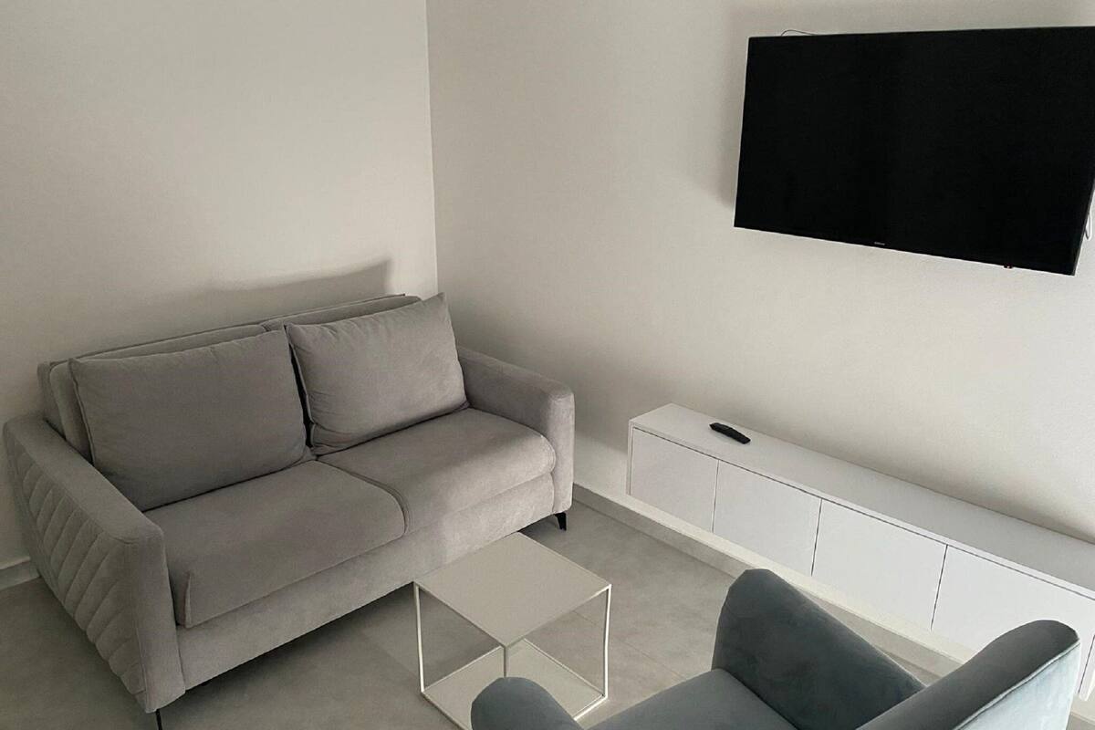 Apartment (One Bedroom Apartment with Balcony 1) | Living room | 32-inch flat-screen TV with satellite channels