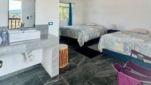 A bedroom with a large bed, a bedside table, a mirror, and a hanging light fixture.