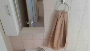 Baño con lavamanos, inodoro y espejo.