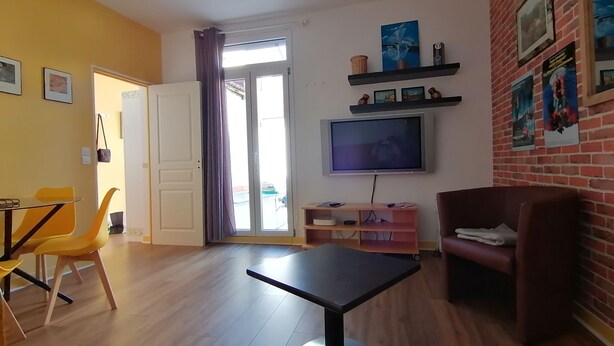A living room with a TV, a sofa, a dining table, and chairs. - Maison Antony, air-conditioned, free parking  (Antony)