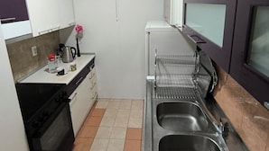 Une cuisine compacte équipée d’une cuisinière, d’un four, de deux éviers et d’un four à micro-ondes.