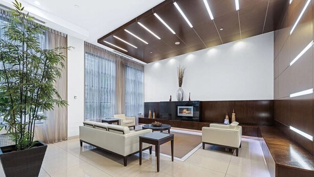 A modern living room with a sofa set, a coffee table, and a fireplace.