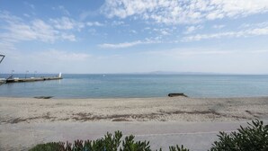 A beach with a clear sky, calm sea, and a rocky shoreline. - Pefkohori Blue View by Luxlikehome (Pefkochori Halkidiki)
