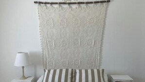 Un dormitorio con una cama, una mesita de noche, una lámpara y un candelabro colgante.