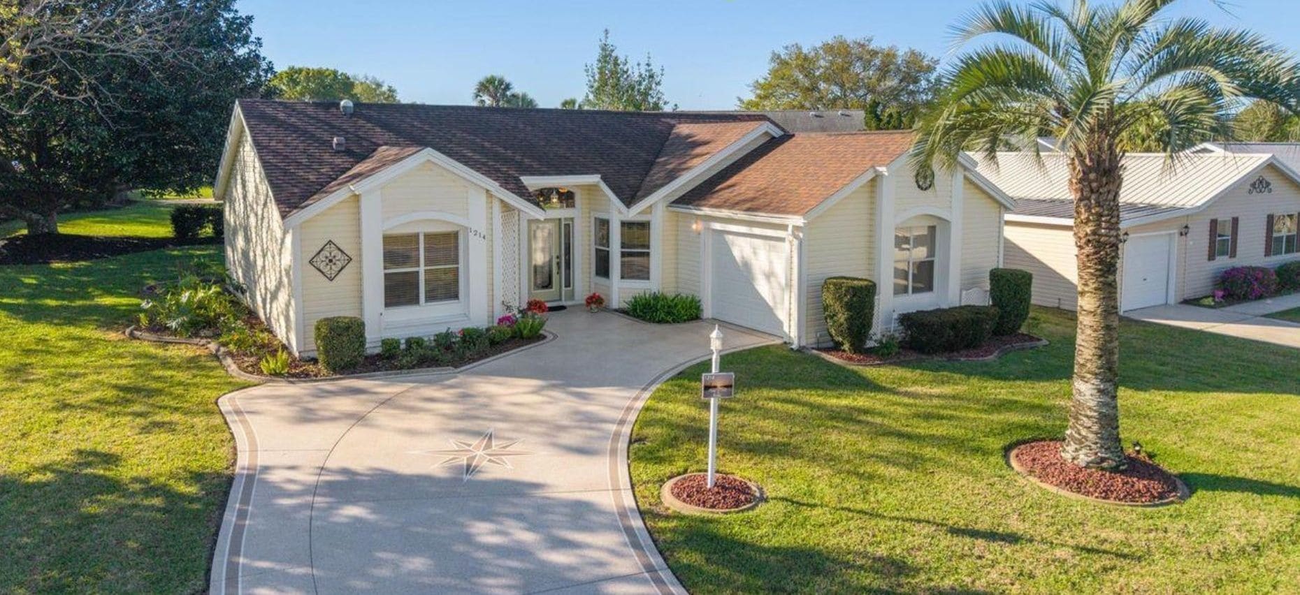 A single-story house with a front entrance, a driveway, and a well-maintained lawn.